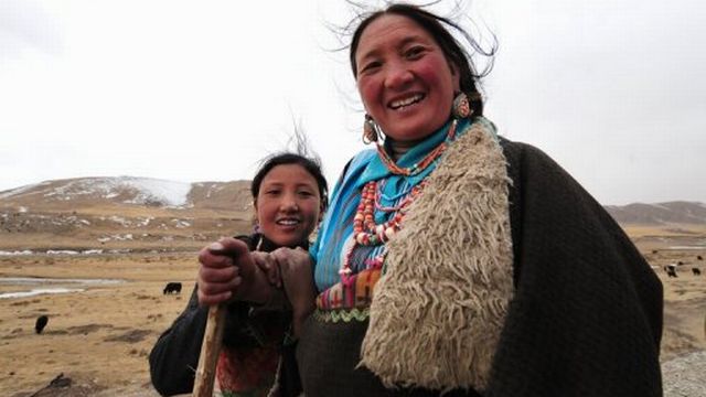 Une mère tibétaine et sa fille accompagne leur troupeau de yaks sur la route vers Lhassa, le 9 mars 2009 [AFP]
