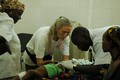 Anne Pittet examine la petite Wassila sur la table d'opération de l'hôpital pédiatrique de Magaria. [Guillaume Arbex - RTS]