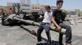 Enfants syriens jouant avec les restes d'un tank, Alep le 3 août 2012. [Ahmad Gharabli - AFP]