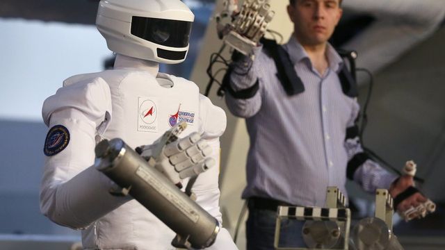 Mercredi 27 novembre: un chercheur russe fait une démonstration du robot SAR-401, qui est destiné à pouvoir travailler dans l'espace. [EPA/SERGEI ILNITSKY - Keystone]