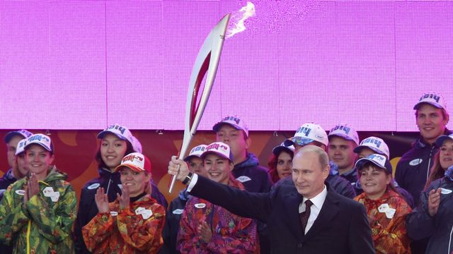 Le président russe Vladimir Poutine brandit la torche olympique à l'occasion du départ du relai de la flamme à Moscou le 6 octobre 2013. [Sergeï Karpukhin - Reuters]