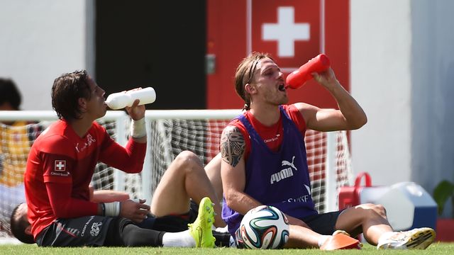 BRAZIL, Porto Seguro : Switzerland's goalkeeper Yann Sommer (L) and defender Michael Lang drink during a training session on June 16, 2014 at the Municipal Stadium in Porto Seguro, during the 2014 FIFA football World Cup in Brazil. AFP PHOTO / ANNE-CHRISTINE POUJOULAT  [Anne-Christine Poujoulat - AFP]