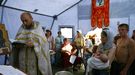 Un prêtre orthodoxe russe baptise un enfant dans un camp de réfugiés situé à environ 15 km de la frontière avec l'Ukraine. [Sergei Venyavsky - AFP]