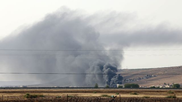Une épaisse fumée noire flottait vendredi au-dessus de la ville d'Aïn al-Arab, à la frontière turco-syrienne. [Ibrahim Erikan / Anadolu Agency - AFP]