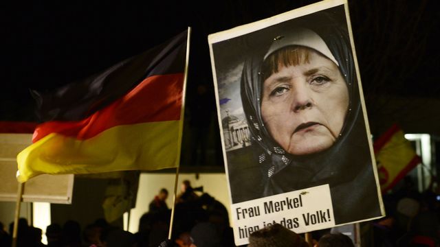 LA manifestation de Pegida du 12 janvier dernier à Dresde, avec une image d'Angela Merkel portnat le foulard. [AP Photo/Jens Meyer]