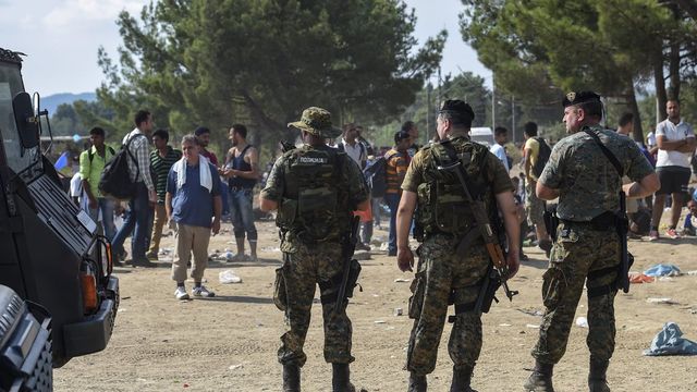 Des forces spéciales gardent la frontière entre la Macédoine et la Grèce, où des milliers de migrants attendent pour passer la frontière. [Keystone]