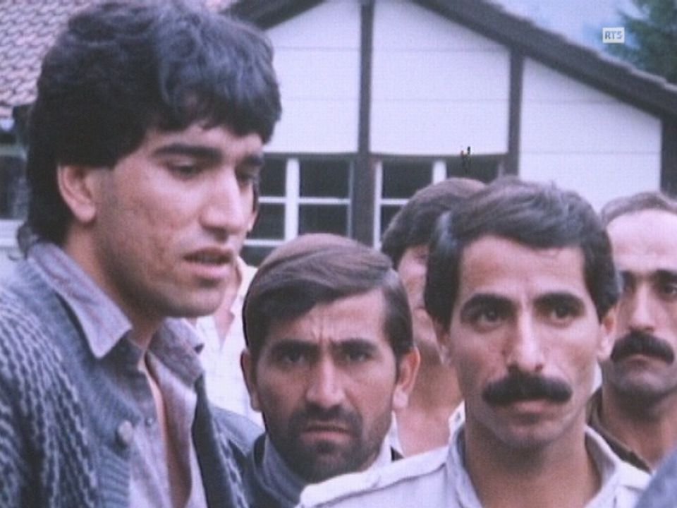 Groupe de requérants d'asile devant le centre de transit de Melchtal en 1988. [RTS]