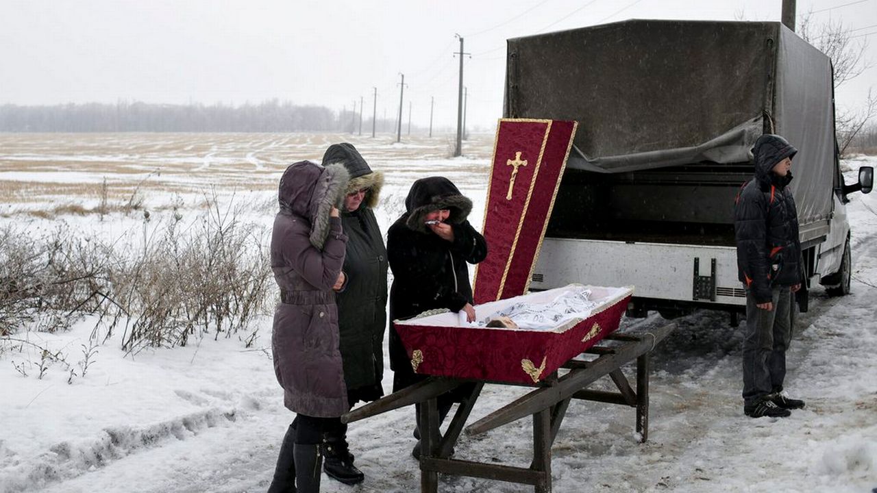 Hommage de parents à une jeune victime des combats dans la région de Donetsk. [Keystone]