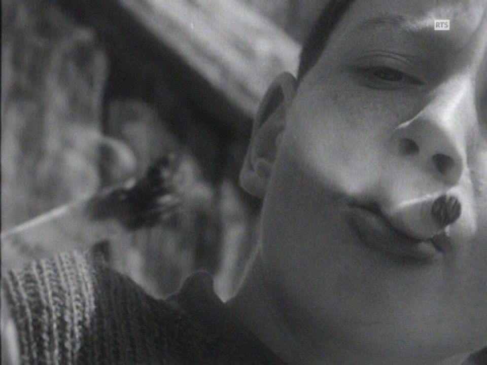 Enfant fumant de l'herbe sèche en 1964. [RTS]