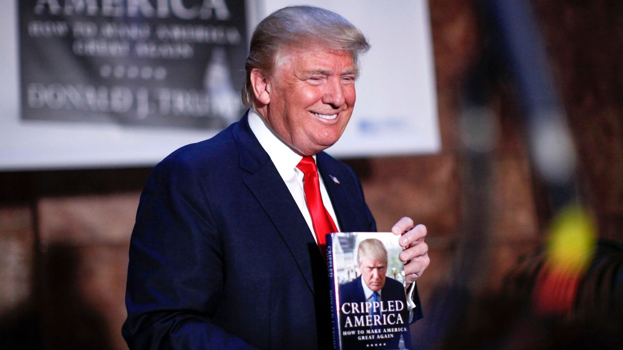 Donald Trump, lors d'une séance de dédicaces pour son livre manifeste "Crippled America - How To Make America Great Again". [KENA BETANCUR - AFP]