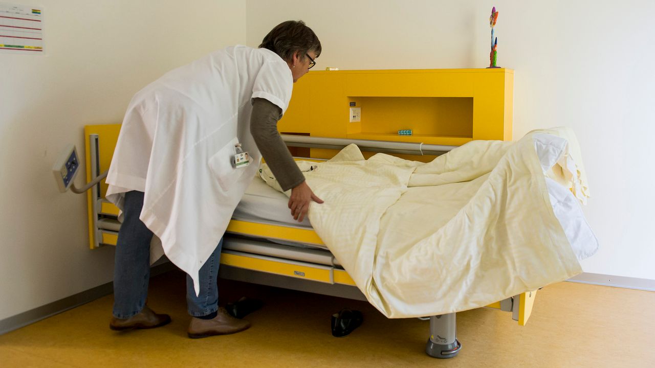 Une infirmière prépare le lit d'un patient à l'Hôpital psychiatrique de Prangins (VD). [Jean-Christophe Bott - Keystone]