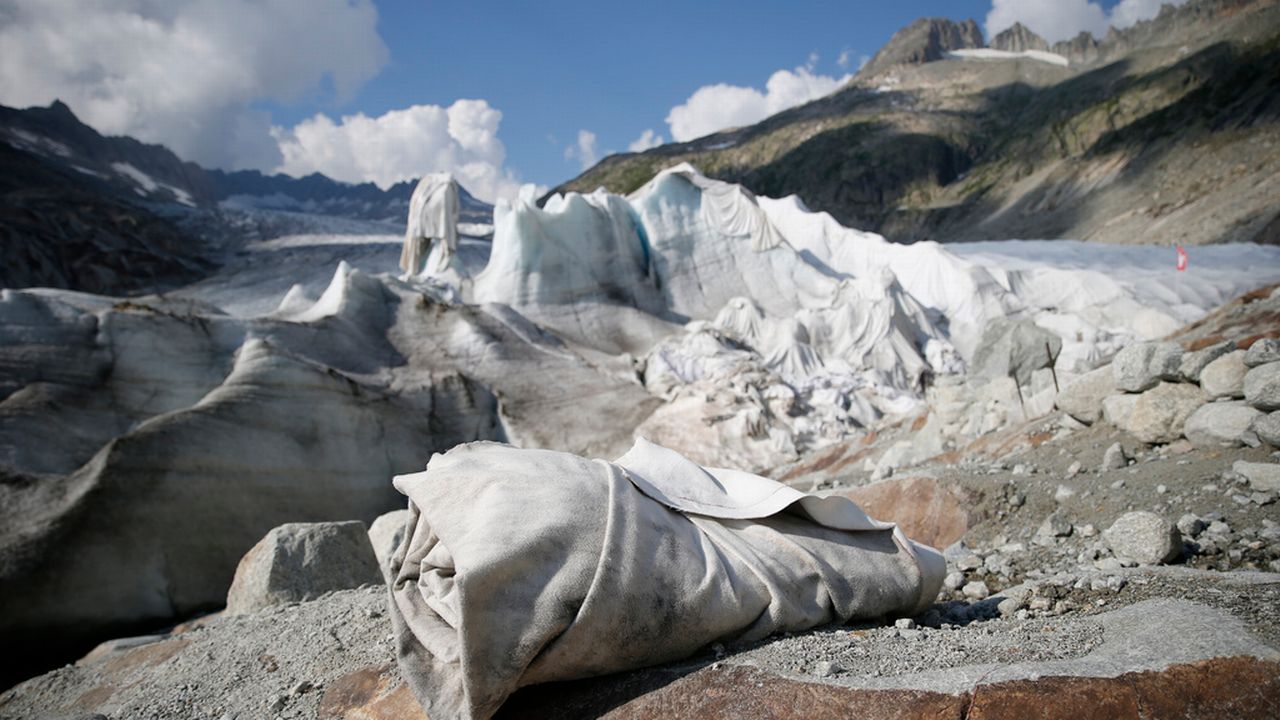 Chaque été, le glacier du Rhône doit être protégé avec des couvertures pour tenter de réduire sa fonte drastique. [Peter Klaunzer - Keystone]