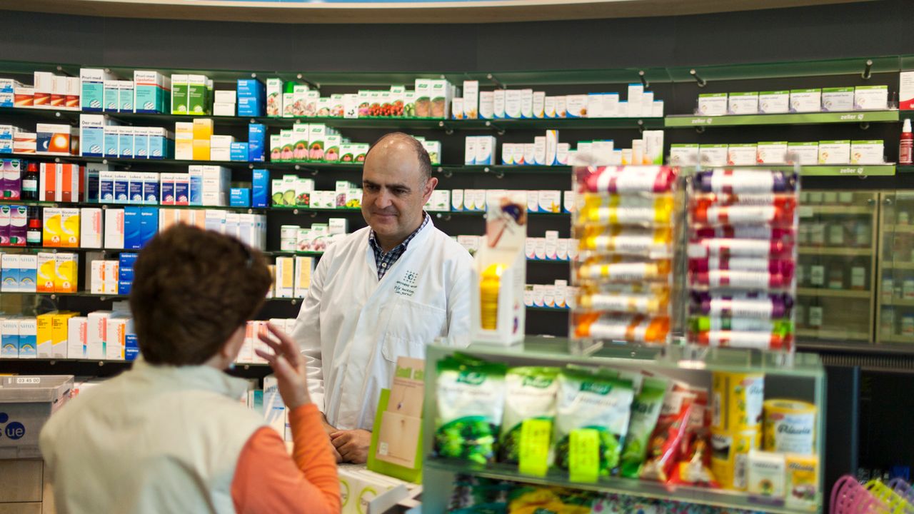 Un pharmacien discutant avec une cliente en Argovie (image prétexte). [Gaetan Bally - Keystone]