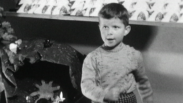 Petit garçon chantant une chanson de Noël en 1960. [RTS]