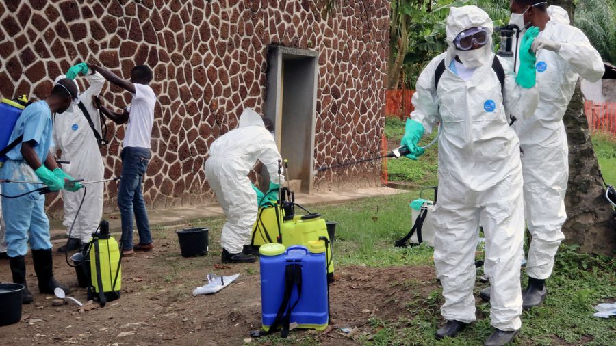 Des collaborateurs des autoritÃ©s sanitaires de la RDC dÃ©sinfectent des personnes et des bÃ¢timents dans un foyer d'Ebola (image d'archives).