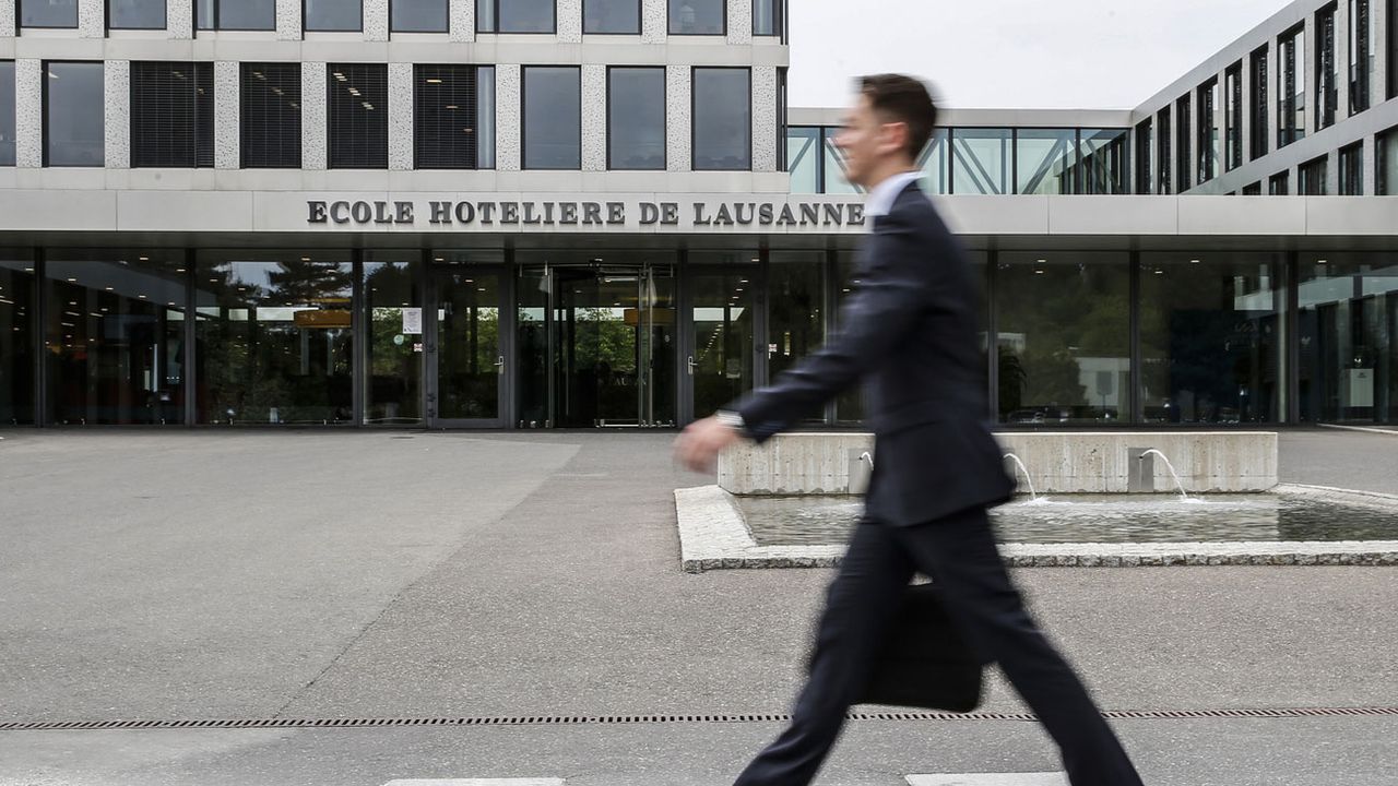 Un étudiant passe devant l'entrée de l'Ecole Hôtelière de Lausanne (EHL). [Peter Klaunzer - Keystone]