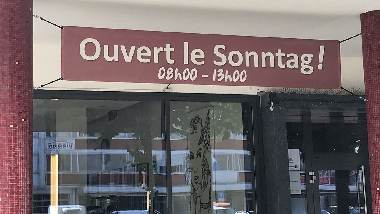 Une devanture de magasin mêlant français et allemand à Bienne (BE). [Philippe Girard - RTS]