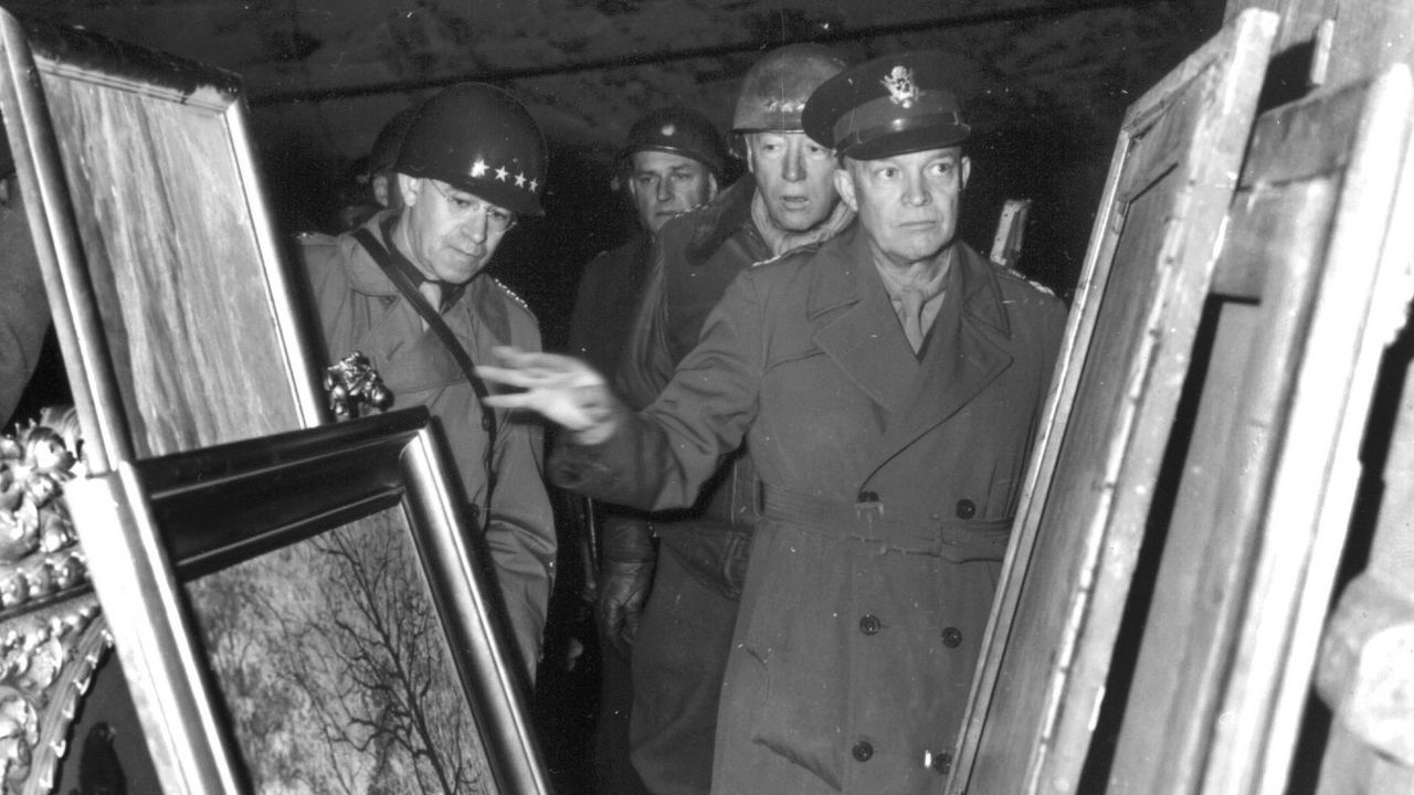 Le général Eisenhower examine le 12 avril 1945 des oeuvres d'art volées par le gouvernement nazi dans les pays occupés et cachés dans une mine de sel en Allemagne. [Keystone]