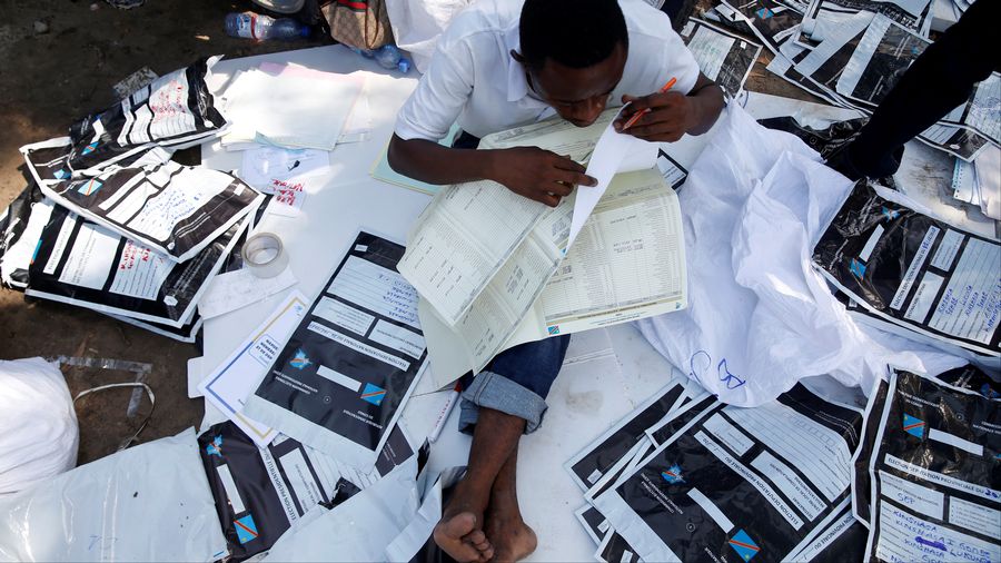 Un employÃ© de la Commission Ã©lectorale nationale indÃ©pendante examine du matÃ©riel Ã©lectoral Ã  Kinshasa.