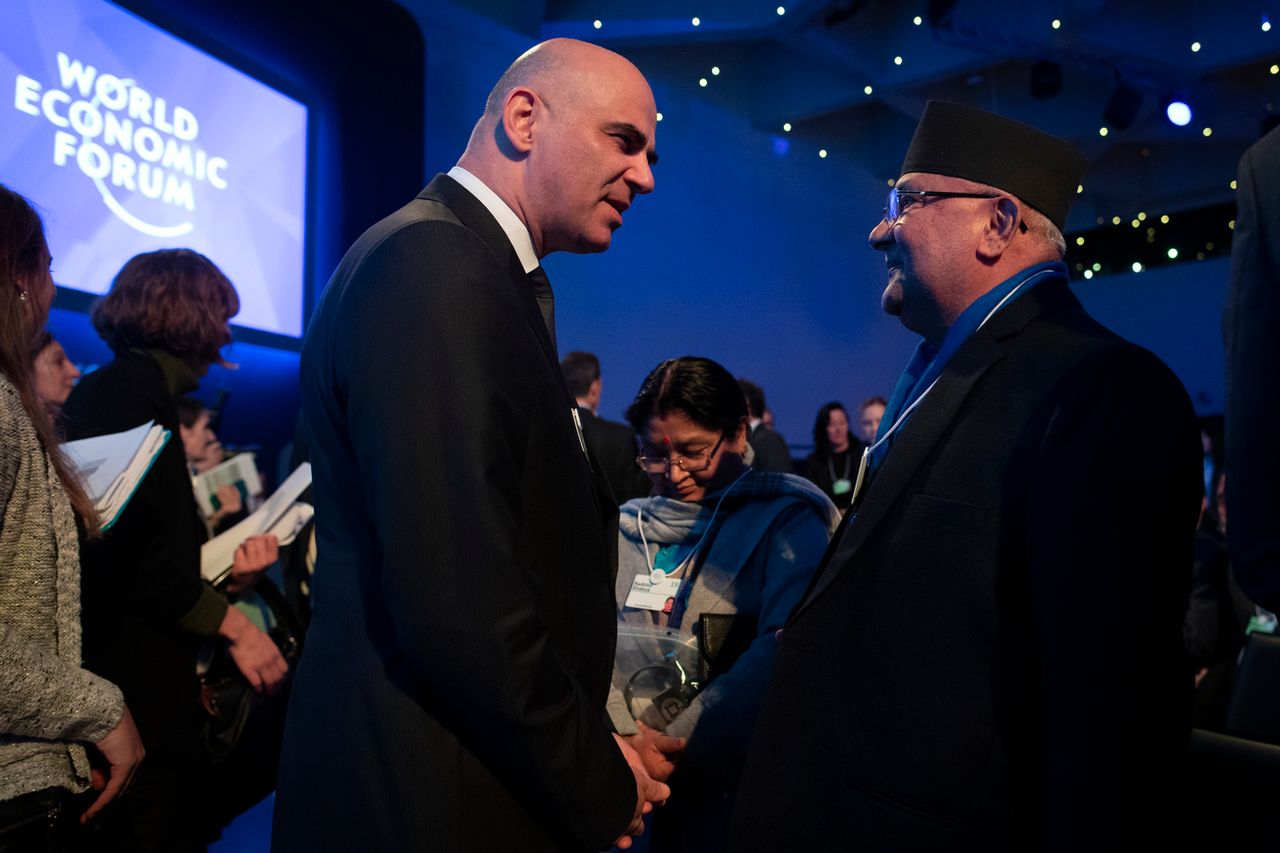 Alain Berset discute avec le Premier ministre népalais Sharma Oli à Davos. [Gian Ehrenzeller - Keystone]