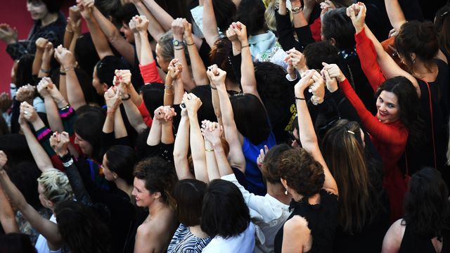 Des réalisatrices, des comédiennes et productrices se tiennent la main sur le tapis rouge de Cannes pour protester contre le peu de femmes primées sur la Croisette. [Anne-Christine Poujoulat  -  AFP]