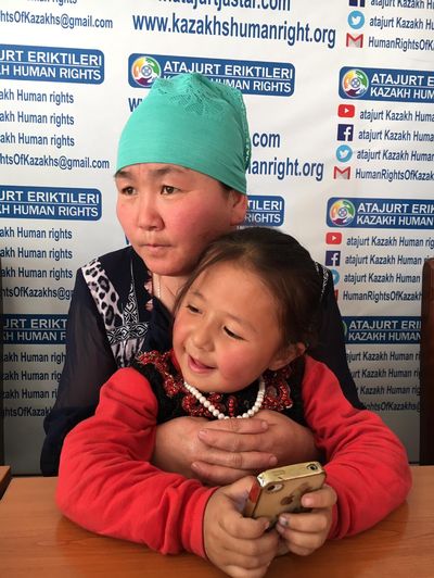 Gulzira Tursinjan, chinoise détenue 15 mois dans des camps au Xinjiang, avec sa fille de 4 ans dans les bras.
