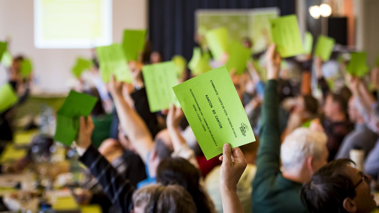 Des délégué-é-s vert-e-s- qui votent lors d'une assemblée. (Image d'illustration). [Jean-Christophe Bott - Keystone]