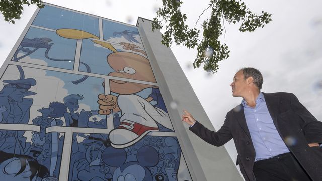 Zep devant une fresque inaugurée en mai 2019 sur un immeuble du quartier d'Onex, à Genève [Martial Trezzini - Keystone]