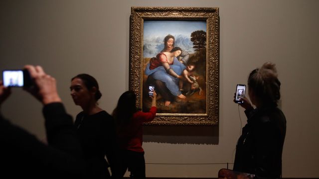 Des visiteurs de l'exposition Leonardo da Vinci" au Louvre à Paris devant la peinture "La Vierge, l'enfant Jésus et Saine Anne". [François Guillot - AFP]