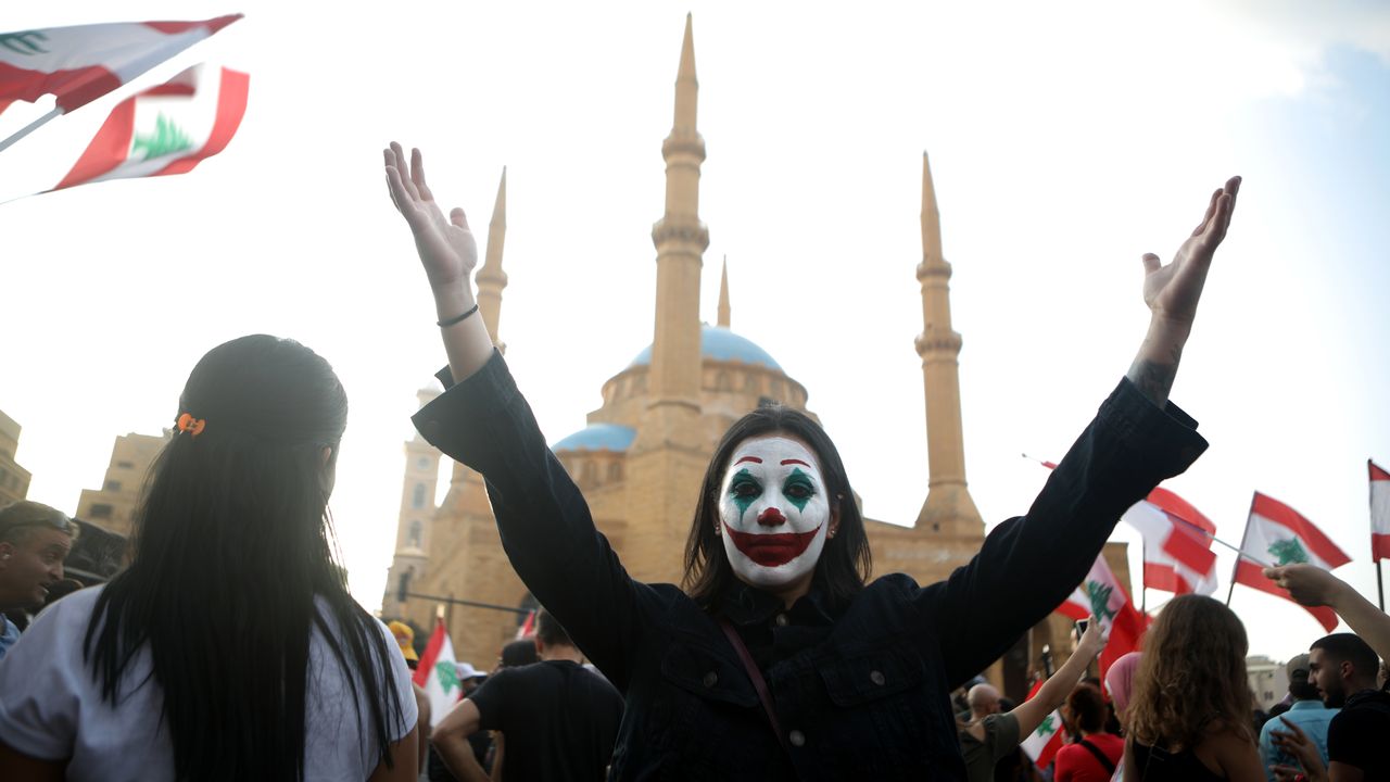 Une manifestante libanaise s'est peint le visage pour ressembler au Joker. Beyrouth, le 19 octobre 2019. [Patrick Baz - afp]