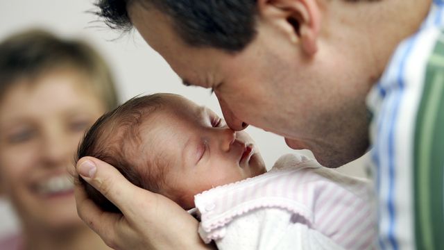 Suite au vote du Conseil des Etats, les pères devraient obtenir deux semaines de congé à la naissance de leur enfant. [Michael Sohn - AP/Keystone]