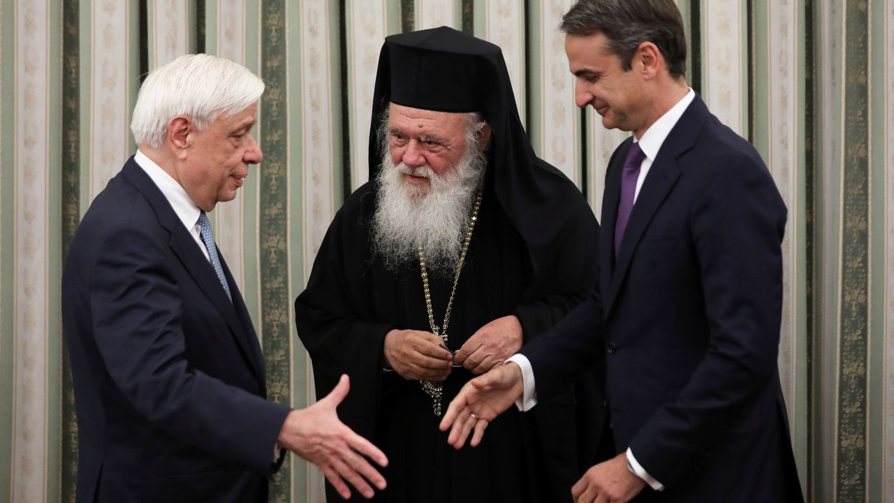 Le premier ministre grec Kyriakos Mitsotakis (à droite) salue le président Prokopis Pavlopoulos, en présence de l'archevêque Hiéronyme II. Athènes, le 8 juillet 2019. [Alkis Konstantinidis - Reuters]