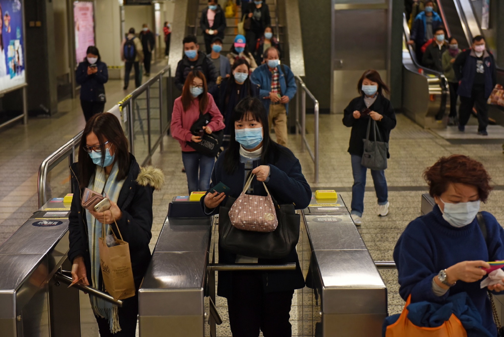 Pendulaires portant des masques dans une station de métro à Hong Kong suite à l'émergence du coronavirus.