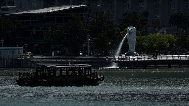 Un bateau presque vide passe devant le célèbre monument Merlion Park à Singapour alors que le tourisme de la cité-Etat a fortement diminué avec la pandémie de coronavirus. [Edgar Su - Reuters]