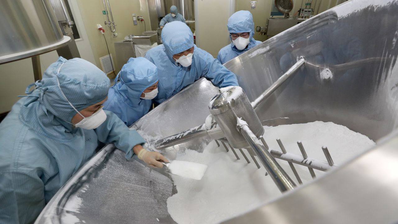 Des employés chinois travaillent sur la production de chloroquine. [Xu Congjun - Keystone/EPA]