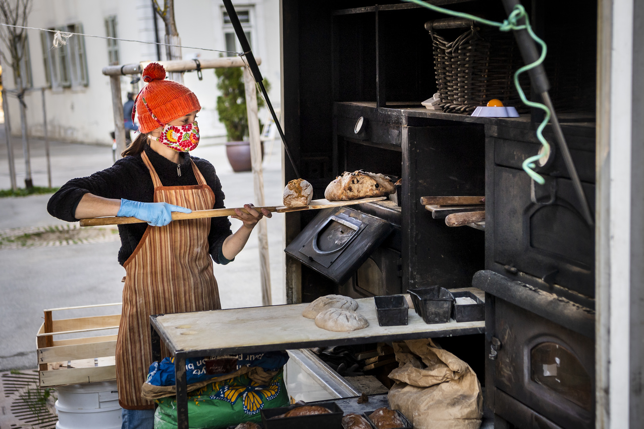 Une marchande prépare du pain sur un stand pendant la crise de Coronavirus à La Chaux-de-Fonds.