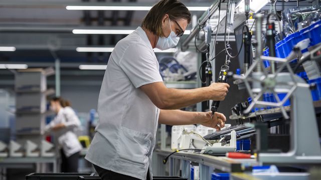 Une technicienne sur une chaîne de montage d'appareils respiratoires, dans l'entreprise Hamilton Ems, le 20 avril 2020. [Alessandro della Valle - Keystone]