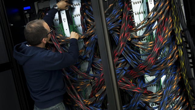 Un technicien analyse le câblage d'un super-ordinateur du CSCS à Lugano. [Gabriele Putzu - Keystone]