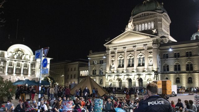 Des manifestants et manifestantes ont investi la Place fédérale à Berne lundi tôt dans la matinée. [Peter Schneider - Keystone]