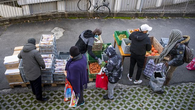 Des bénévoles de l'association Solid-ère distribuent des sacs alimentaires à Lausanne. [Jean-Christophe Bott - Keystone]