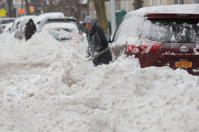 A man clears his car in Brooklyn on Tuesday morning [Brendan McDermid - Reuters]