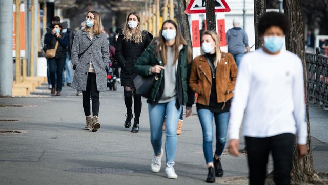 Des personnes portent un masque dans les rues de Lugano. [Ti-Press/Elia Bianchi - Keystone]