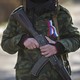 Un soldat à l'uniforme anonyme, portant un ruban aux couleurs de la Russie, devant la base militaire de Simferopol en Crimée, le 13 mars 2014. [Vadim Ghirda - AP/Keystone]