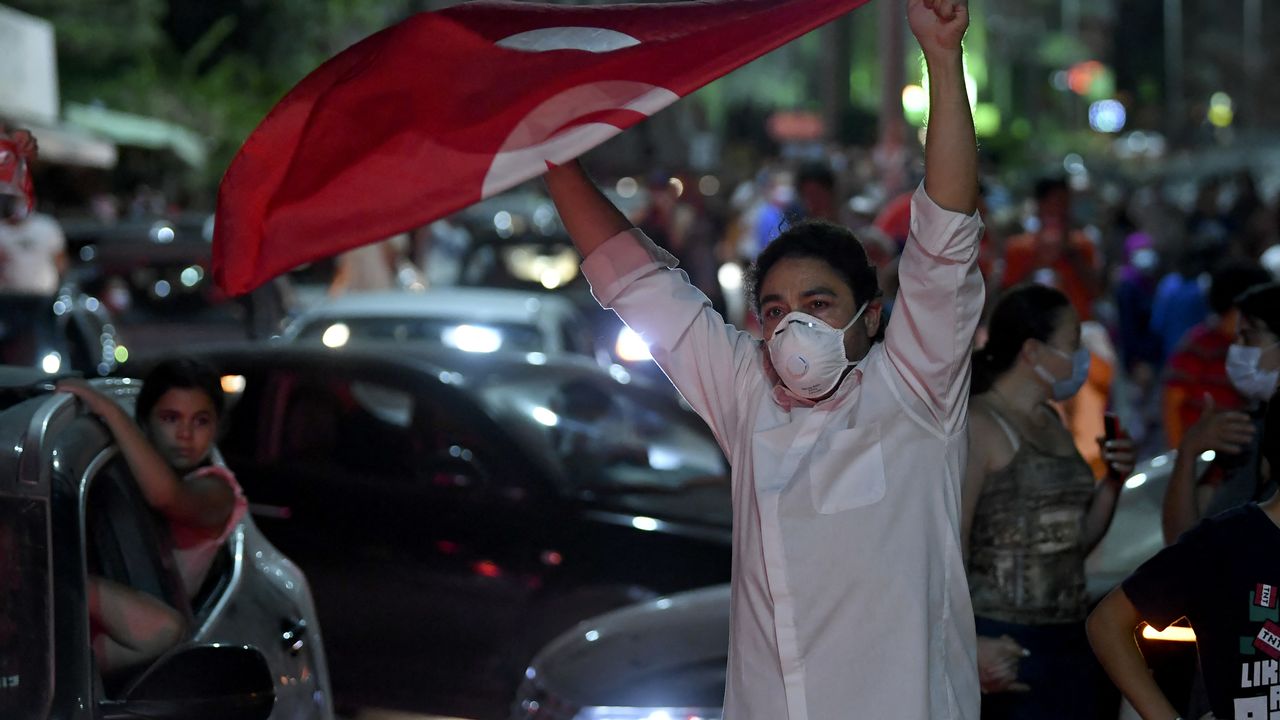 Klaxons, feux d'artifice, des foules de Tunisiens sont descendues dans les rues, bravant le couvre-feu, pour manifester leur joie après l'annonce du président Saied. [Fethi Belaid - AFP]