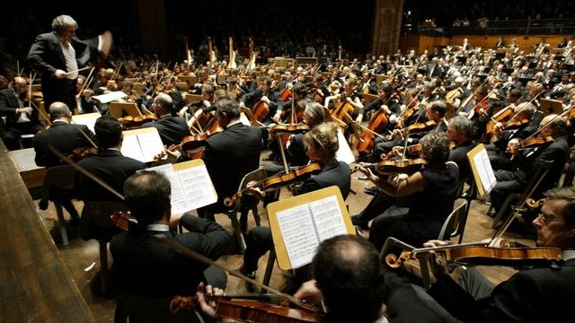 Le chef d'orchestre Alain Lombard (G) dirige le "grand orchestre des musiciens de France", le 15 novembre 2004 à la Halle aux Grains de Toulouse. [Georges Gobet - AFP]