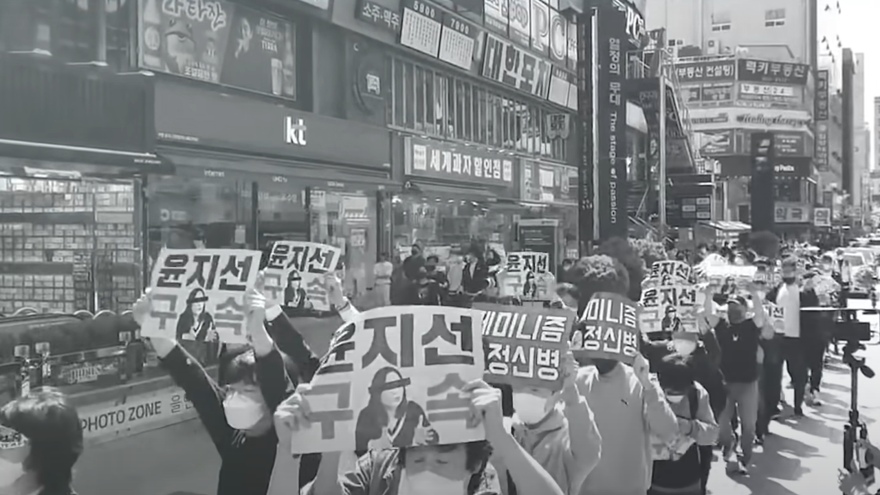 Capture d'écran de la chaîne Youtube "Nouvelle solidarité masculine", montrant des militants tenant des pancartes.  [Youtube]