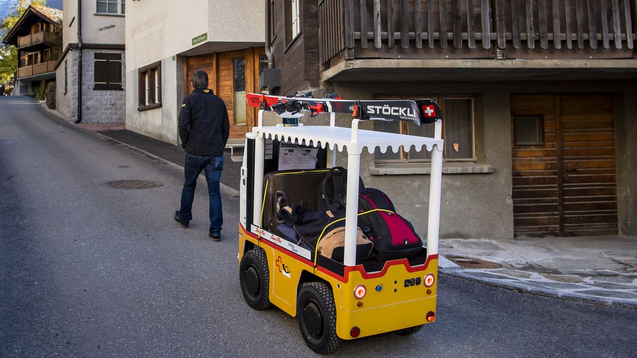 Vendredi 22 octobre: "Robi" le robot à bagages circule à Saas Fee (VS) après avoir été présenté à la presse. Il doit permettre de faciliter le déplacement des touristes avec leurs bagages dans la station. [Jean-Christophe Bott - Keystone]