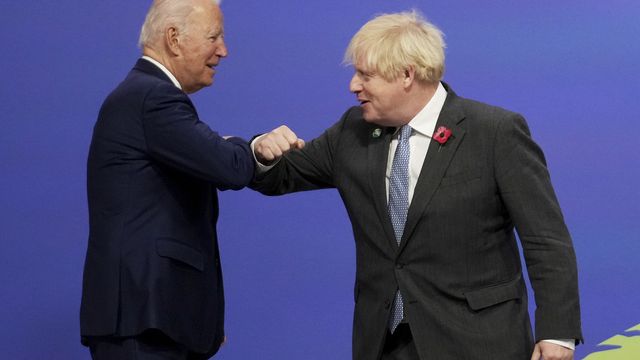 Le salut de Boris Johnson à Joe Biden en ouverture de la COP26 à Glasgow. [Christopher Furlong/Pool via AP - Keystone]