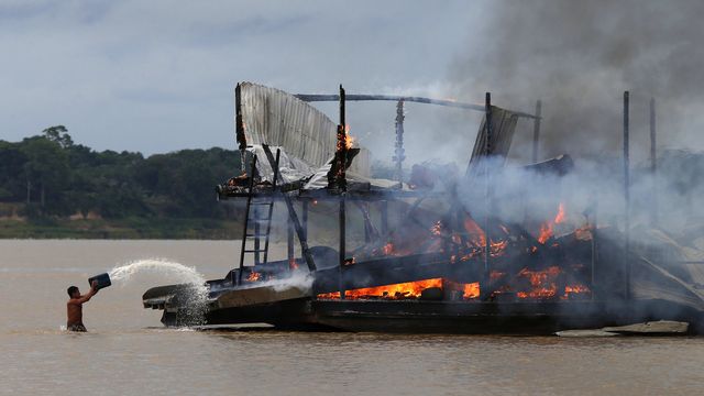 Barge incendiée lors de l'opération contre les oprpailleurs sur le fleuve Madeira, 28.11.2021. [Edmar Barros - AP/Keystone]
