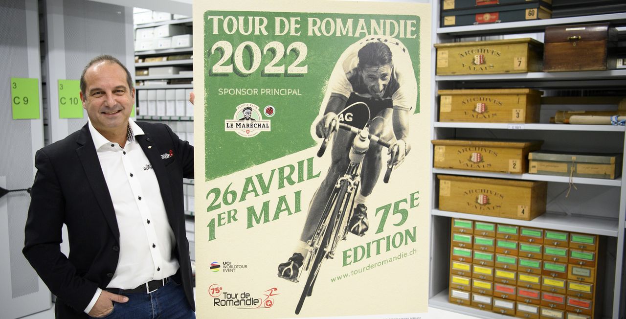 Richard Chassot, directeur du Tour de Romandie, pose avec l'affiche du TDR 2022 dans les archives cantonales valaisanne lors de la présentation à la presse de la 75e édition. [Laurent Gillieron - Keystone]
